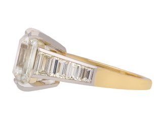 Emerald cut diamond flanked solitaire ring, circa 1970. Hatton Garden