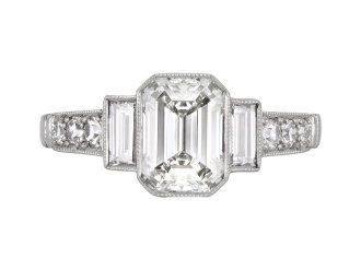 Emerald-cut diamond flanked solitaire ring, circa 1950.